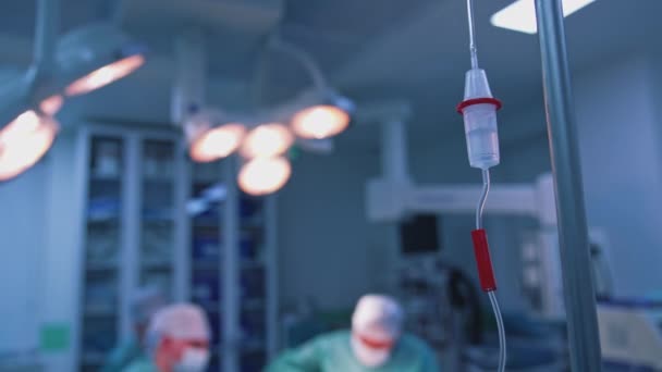 クリニックで医療用ドロッパー 手術中の投薬 静脈内注入によるドロッパー 液体の塩分がゆっくりと流れていく 傷ついた手術の背景 — ストック動画