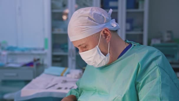 Chirurg Rozmytym Tle Sali Operacyjnej Portret Lekarza Mundurze Medycznym Przeprowadzającego — Wideo stockowe