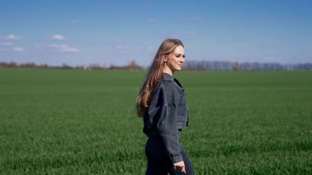 迷人的年轻女子在绿地上散步 美丽的模型 长发飘扬 绿色的自然背景 慢动作 — 图库视频影像