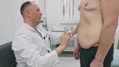 Doktor adamı estetik ameliyata hazırlar. Erkek cerrah ameliyattan önce hastanın vücudunda izler bırakır. Klinikte yağ aldırma.