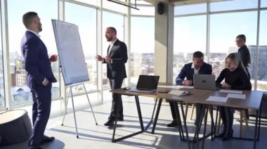 Şehirdeki ofis merkezindeki iş adamları. İş adamları ve kadınlar yeni bir proje üzerinde çalışıyorlar. Bir grup ofis çalışanı iş planını tartışıyor.
