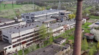 Eski bir fabrikanın panoramik manzarası. Büyük tuğla boruları olan terk edilmiş sanayi bölgesi. İlkbaharda üretimi mahvoldu. Hava görünümü.