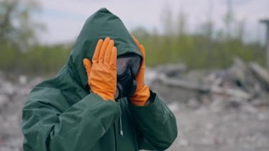 Kimyasal koruma giysisi giyen adam. Güvenlik üniformalı ve gaz maskeli bir insan terk edilmiş bir yerde duruyor. Biyolojik saldırı.