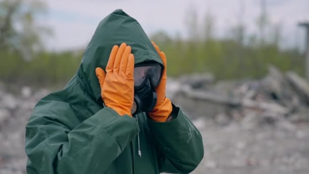 化学物質保護スーツを着ている男 放置された場所に立っている安全制服およびガスマスクの人間 生物学的攻撃 — ストック動画