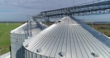 Tahıl asansörlerinin tepeleri. Tahıl depolama ve işleme için modern gümüş ambarlar. Güneş ışığında alüminyum kapların dışı. Havadan bak..