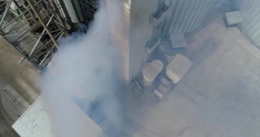 Fabrikadaki kurutucudan duman yükseliyor. Zararlı buharla kaplı sanayi bölgesi. Üst Manzara. Kamera yükseliyor.
