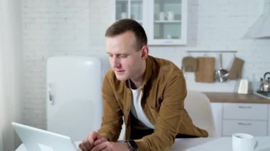 Genç adam evde bir video görüşmesi yapıyor. Uzak bir iş. Adam bir müşteriyle dizüstü bilgisayardan konuşuyor. Uzaktan eğitim.