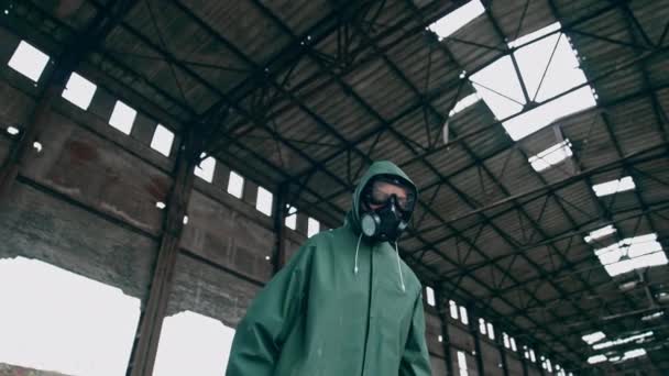 保護ユニフォームとガスマスクの人 化学攻撃の放出後の汚染されたゾーン 破壊された建物の背景にヘスマットスーツを着ている女性 — ストック動画