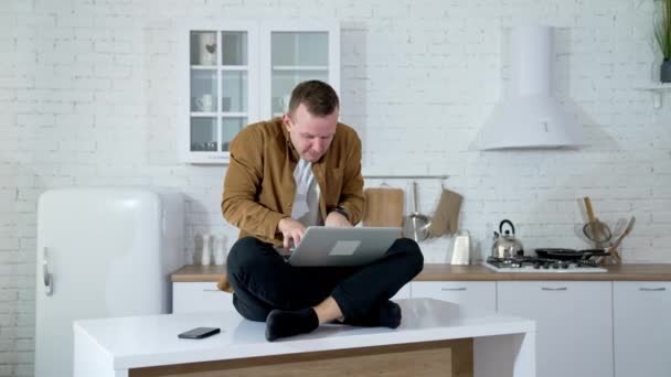 Tipo Engraçado Sentado Numa Mesa Cozinha Escrever Num Portátil Jovem — Vídeo de Stock