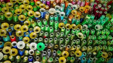 Renkli dikiş iplikleri arka planda. Birçok farklı renk ipliği makarası. Dikiş aletleri. Hobiler ve el sanatları.