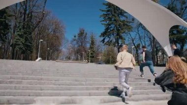 Parka koşan mutlu arkadaşlar. Güneşli bir günde arkadaşlarıyla parkta vakit geçiren yakışıklı adamlar. Gençler birlikte vakit geçiriyorlar..