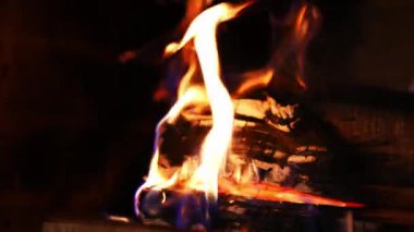 Şöminede yanan odun. Şöminede sıcacık bir ateş. Ahşap odunların üzerinde güzel turuncu ateş alevi. Yakın plan..