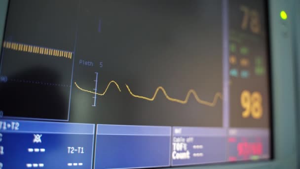 スクリーン上の心臓血管と数字 黄色い線は黒いスクリーンの特定の心拍数で動きます モニター上の心臓グラムの重い行の動き クローズアップ — ストック動画