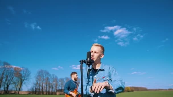 Молодая Музыкальная Группа Выступает Фоне Голубого Неба Мужчина Поет Микрофон — стоковое видео