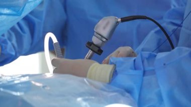 Doktor ameliyat sırasında tıbbi alet kullanır. Klinikte özel ekipmanlar cerrahın elinde. Modern tıp. Yakın plan..