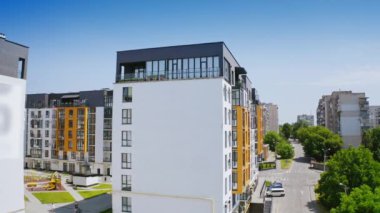 Güneşli gündüz vakti şehir geçmişi. Yeni bir apartmanın dışında. Geniş pencereli ve balkonlu yüksek binaların modern tasarımı.