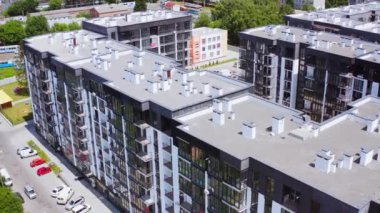 Şehirdeki modern apartmanlar. Modern tasarımın yüksek binaları olan yeni bir yerleşim yeri. Kentsel arka planda çok katlı binaların çatıları. Hava görünümü.