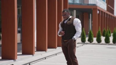 Şehirdeki Afrikalı Amerikalı. Ciddi bir iş adamı, siyah tenli, modern ofis merkezinin yakınında birini bekliyor..