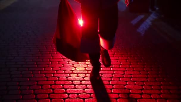 圣诞老人的腿 弗罗斯特神父圣诞节时带着红包礼物外出 圣诞老人的黑色靴子在雪地的黑暗中行走在人行道上 — 图库视频影像