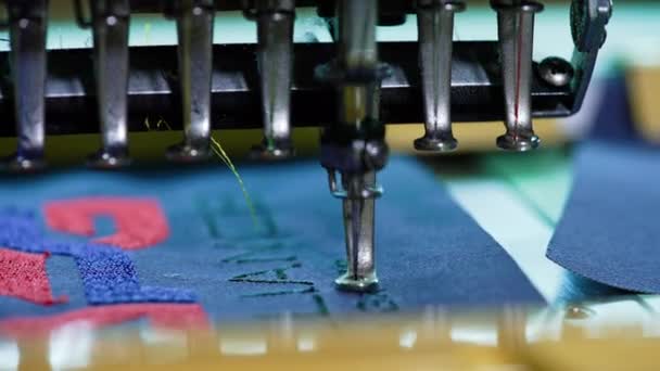 糸のステッチを作るドレッシングマシン 青い布の自動刺繍機械の仕事 縫う針は生地で急速に動いています クローズアップ — ストック動画