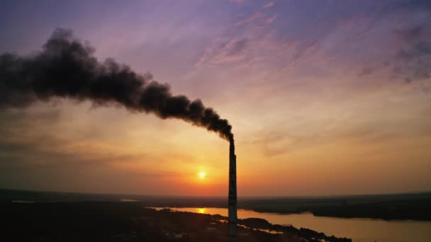 工业的浓烟弥漫在空气中 抽烟的烟囱在日落时污染环境 晚上在河边附近的有害的工业厂房 — 图库视频影像
