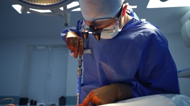 医師の手の中にある手術器具 医療用ユニフォームおよび滅菌手袋の外科医は クリニックで特別なツールを使用して患者に手術を行います — ストック動画