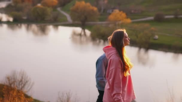 ハッピーガールとボーイフレンドが夕方に歩いている 若いカップルは美しい自然の背景で一緒に時間を過ごしました スローモーション — ストック動画