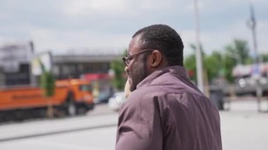 Siyah derili bir iş adamı telefonda konuşuyor. Gömlekli Afro-Amerikan bir adam şehir geçmişi hakkında iş konuşması yapıyor. Yörünge görünümü.
