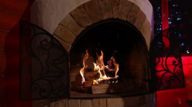 Güzel taş şömine. Şöminede yanan odun. Kış tatilinde şöminede sıcacık bir ateş. Ev konforu.