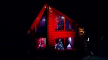 Mutlu aile evde yeni yıl hazırlığı yapıyor. Noel 'den önce rahat bir evde hoş bir atmosfer. Aile Noel ağacını süslüyor. Kışın sıcacık bir binaya dışarıdan bak..