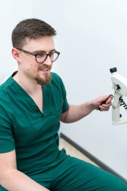 Hastane odasında çalışan üniformalı bir doktor. Yakışıklı tıbbi uzman portresi..