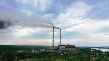 Endüstriyel fabrika havaya zehirli emisyonlar yayar. Duman kulüpleri gökyüzünün arka planındaki bacalardan çıkar. Doğa tehlikede..