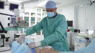 Doktor, anestezi ile yağ aldırma sırasında yağları alıyor. Profesyonel cerrah ameliyat sırasında şırıngayla çalışır. Yağ aldırma.