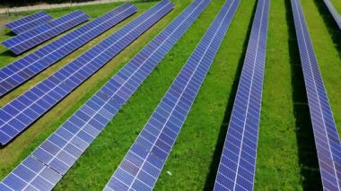 Sahada güneş enerjisi istasyonu var. Çevredeki yenilikçi güneşli pillerin arka planı. Uzun fotovoltaik güneş panellerinin üzerinden uçmak. Temiz alternatif enerji.