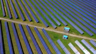 Dev bir güneş enerjisi santrali. Bir güneş çiftliğinin mavi fotovoltaik panelleri. Güneş 'ten ekolojik enerji üretimi için modern endüstri. Hava görünümü.