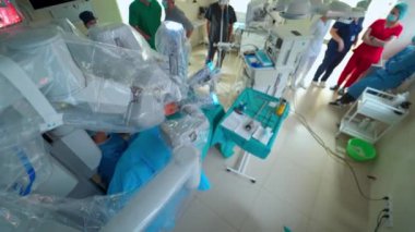 Minimum invaziv ameliyat sırasında akıllı makine. Hastaya mikro cerrahi yapan gelecekçi robotik ekipmanlar. Tıp çalışanları robot cerrahisini gözlemliyor. Üst görünüm.