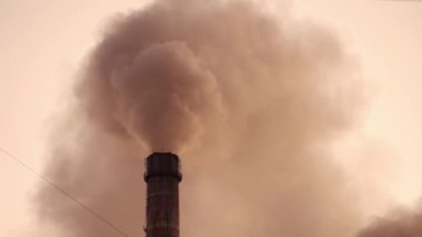 Bacadan havayı dolduran yoğun zehirli emisyonlar. Kirli sis akşam gökyüzündeki atmosferi kirletir. Ekolojik felaket.