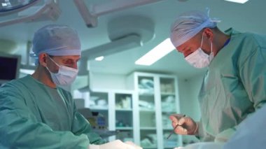 Ameliyathanede cerrahların işi. Tıp üniformalı doktorlar yağ çıkarmak için cerrahi bir prosedür uyguluyorlar. Klinikte yağ aldırma.
