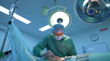 Cerrahi müdahale. Profesyonel doktor tıbbi lamba altında yağ aldırma prosedürü uyguluyor. Modern klinikte yağ ayıklama. Aşağıdan görüntüle.