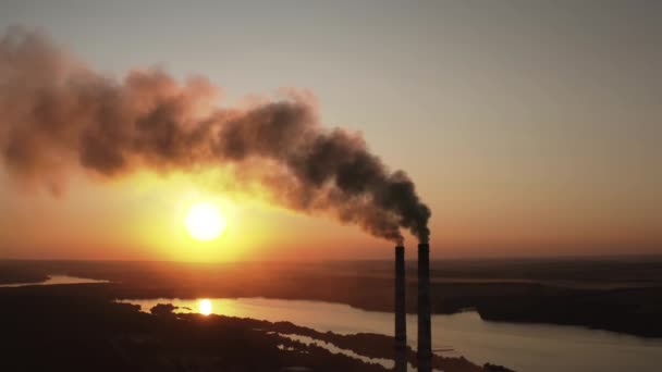 工場は日没時に環境を汚染する 夜空の背景に対してチューブを浴びる有毒な企業煙突は黒い煙を解放します 自然における有害な製造のパイプの喫煙 — ストック動画