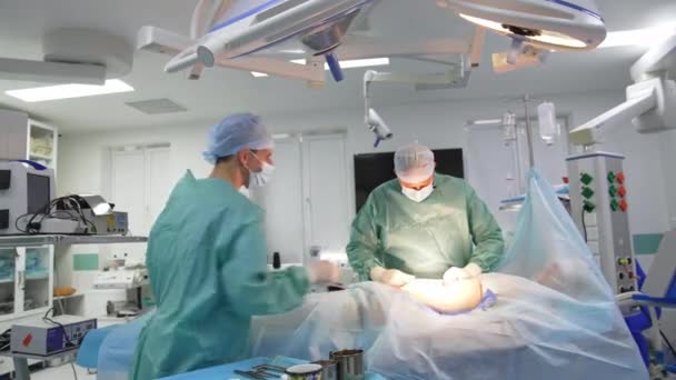 ドクターは脂肪吸引の手術をする 外科医は 手術中に腹部の脂肪を集めました 患者の体のための化粧品手術と改善 — ストック動画
