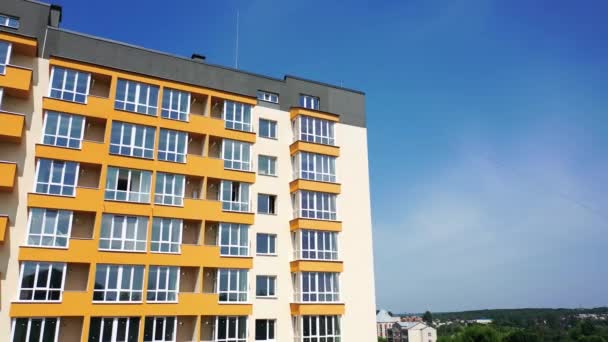 这座城市里新的多层楼房 现代公寓楼 有很大的窗户和五彩斑斓的墙壁 为有天空背景的城市居民建造了一座新房子 — 图库视频影像