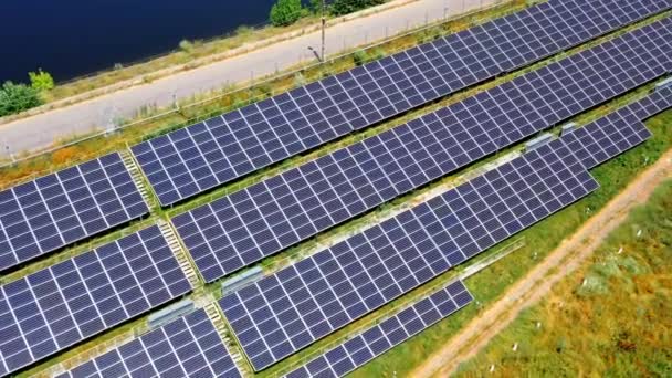 在长太阳能电池板上飞行 阳光灿烂的日子 光伏太阳能电池在道路附近 替代绿色能源 空中景观 — 图库视频影像