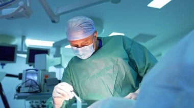 Konsantre plastik cerrah hastanın vücudunu işaretliyor. Tıbbi üniformalı ve maskeli profesyonel doktor hastayı ameliyathanede liposuction prosedürüne hazırlıyor..
