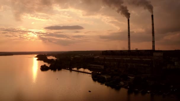 夜の自然の中で煙の管が付いている工場 危険な製造業の汚染された大気 夕暮れに川の近くにある工場 エコロジー問題 — ストック動画