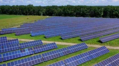 Doğadaki güneş enerjisi çiftliği. Mavi fotovoltaik paneller güneşten temiz enerji topluyor. Kırsal kesimde güneşli bataryalar. Yukarıdan görüntüle.