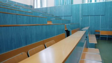 Boş konferans salonu. Eğitim merkezinde tahta masalı ve sandalyeli oditoryum. Üniversitede öğrencilerin olmadığı konferans salonu..