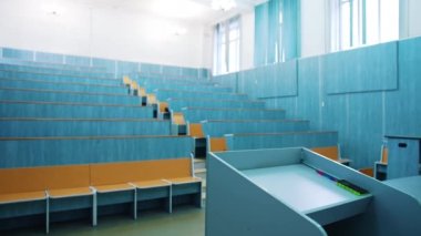 İnsansız ahşap masaları olan modern oditoryum. Boş masaları olan büyük bir toplantı salonu. Karantina sırasında üniversitenin konferans salonunda kimse yok..
