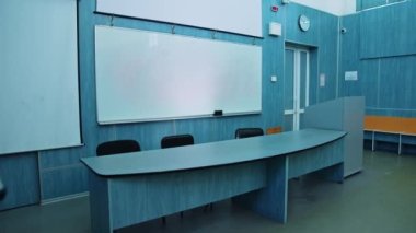 Modern ekipmanlı Presidium bir yer. Tahtalı oditoryum, beyaz tahta ve öğretmen masası. Mavi renkli güzel boş sınıf.