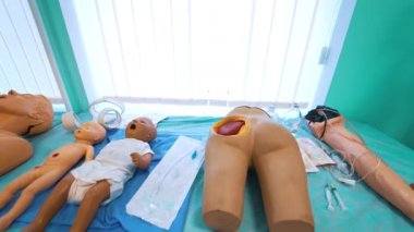Tıbbi deneyimler için kuklalar sergisi. Plastik bebekleri ve hasta parçaları modeli olan üniversite öğrencileri için oda.